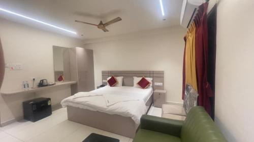 a bedroom with a bed and a green couch at Sithara Grand in Ongole