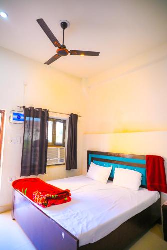 a bedroom with a bed with a ceiling fan at Shri ram doot niwas in Ayodhya