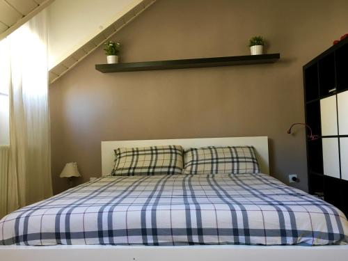 una camera con un letto con una coperta blu e bianca a quadri di Loft l'Alessandra a Bolzano