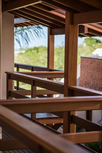 a wooden balcony with a view of a window at Pousada Areias do Rosa in Praia do Rosa