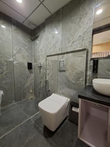 a bathroom with a toilet and a shower and a sink at White Panda hotels Shree Radhe in Dwarka