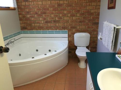La salle de bains est pourvue d'une baignoire blanche et de toilettes. dans l'établissement Avoca Motel, à Avoca