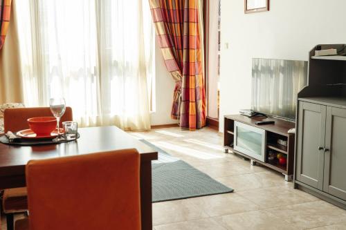 a living room with a table and a tv at Mirage Collective in Nesebar