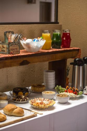 a table with various food items on a table at Pousada Areias do Rosa in Praia do Rosa