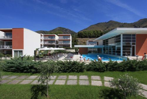 een resort met een zwembad en bergen op de achtergrond bij Sporting Club Resort in Praia a Mare