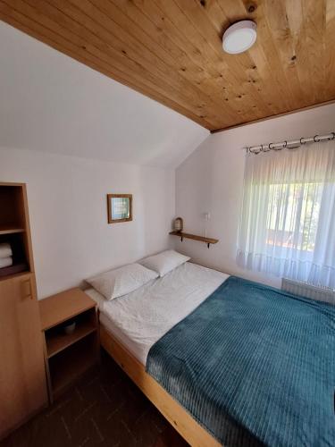 a bedroom with a large bed with a blue blanket at Jefimija in Jasikovice