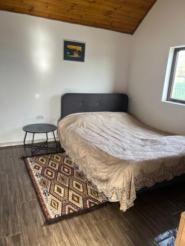 a bedroom with a bed and a table on a rug at Hill's Peak in Cacica