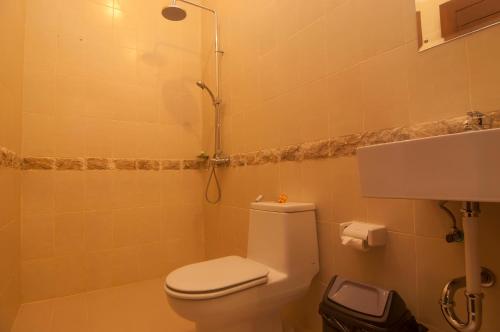 a small bathroom with a toilet and a shower at Duyung Homestay in Sanur