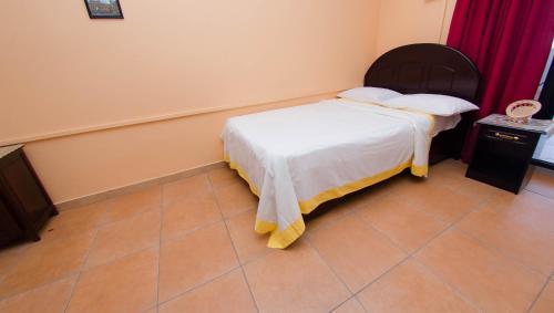 a small bedroom with a bed and a tiled floor at SM Lodge in Trou dʼ Eau Douce