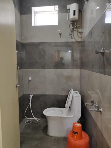 a small bathroom with a toilet and a window at Eshwaraa Cottage in Palni