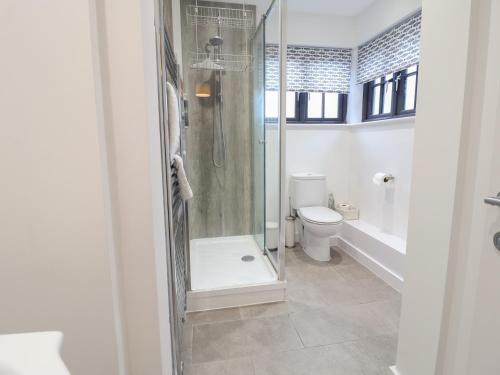 a bathroom with a shower and a toilet at Corner Cottage, Thorpeness in Thorpeness