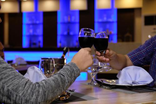 two people holding glasses of wine at a table at Kew Hotel Tagbilaran in Tagbilaran City