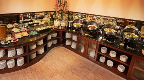 a buffet line with pots and pans of food at Blue Sky Pandurata Hotel Cikini in Jakarta