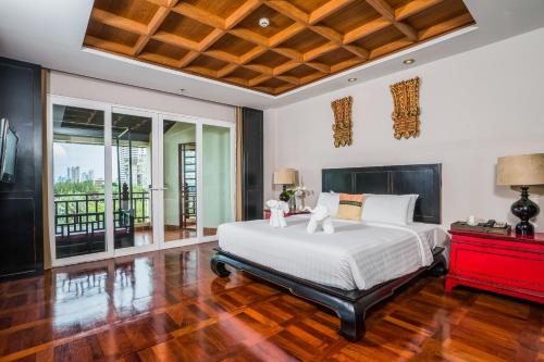 a bedroom with a large white bed and a red dresser at Dor-Shada Resort By The Sea in Na Jomtien