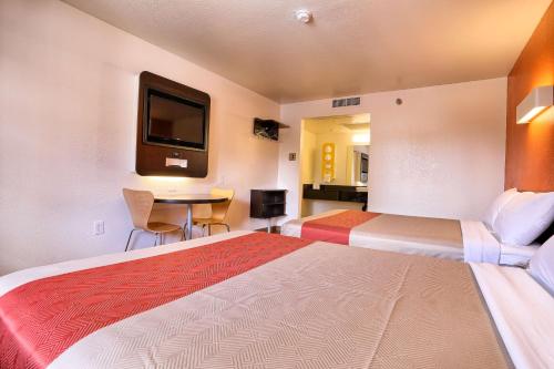 a hotel room with two beds and a table at Super 8 by Wyndham Petaluma in Petaluma