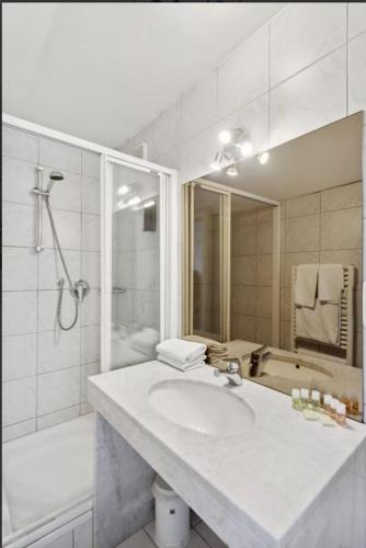 a bathroom with a sink and a shower and a tub at Gästehaus Blaue Ecke in Adenau