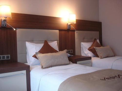 a hotel room with two beds and two lamps at Vesta Fuar Otel in Konak