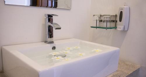a white sink with flowers on it in a bathroom at Hak Boutique Hotel in Siem Reap