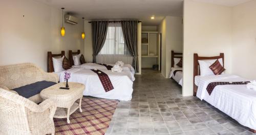 une chambre d'hôtel avec deux lits et un canapé dans l'établissement Hak Boutique Hotel, à Siem Reap