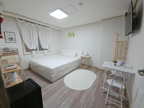 a bedroom with a bed and a tv and a table at G Hotel near Busan Station in Busan