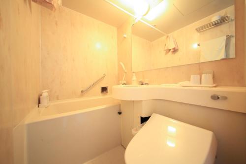 a white bathroom with a toilet and a sink at Park Hotel Miyabitei in Noboribetsu