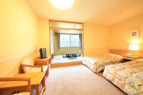 a hotel room with two beds and a television at Park Hotel Miyabitei in Noboribetsu