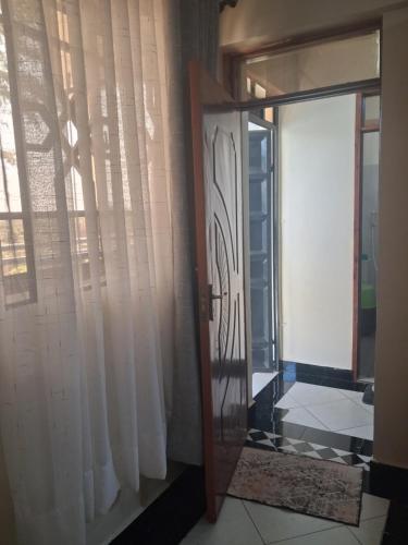 a door to a room with white curtains and a window at PAZURI - Homes in Voi