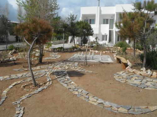 a garden with rocks and trees in front of a building at Mandorla Apartments in Lardos