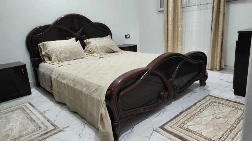 a bedroom with a large wooden bed in a room at Studio Bayen in Douz