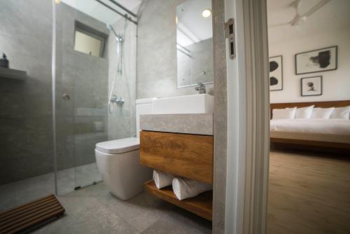 a bathroom with a toilet and a sink and a shower at Luxe320 in Colombo