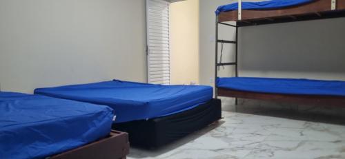 two bunk beds in a room with blue sheets at Rancho Duarte in Itanhaém