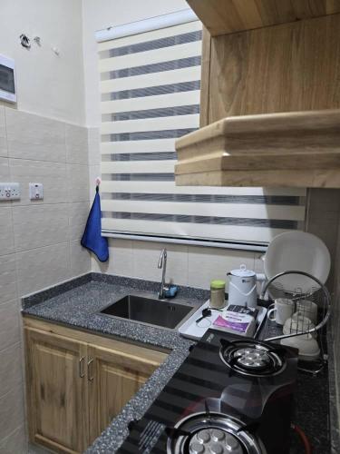 a small kitchen with a sink and a stove at Kibs Apartments in Dodoma