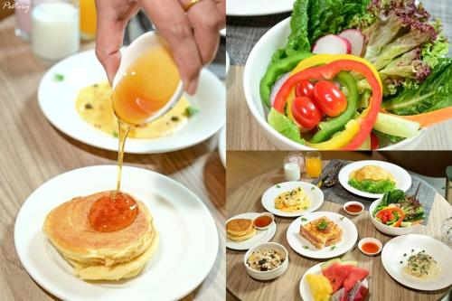 a table with plates of food and a person pouring sauce on a pancakes at Away Bangkok Sukhumvit in Bangkok