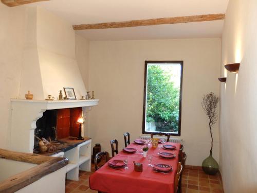 une salle à manger avec une table et une cheminée dans l'établissement La Maison de l'Isle, à LʼIsle-sur-la-Sorgue