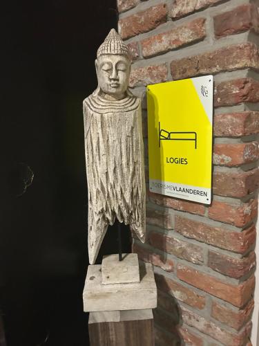a statue of a bust next to a brick wall at Steves Place Haasdonk in Beveren