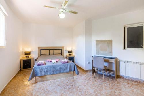 a bedroom with a bed and a table and a desk at Paraíso Familiar en Marisol Park Bungalow con Piscina, Tenis y Parking in Calpe