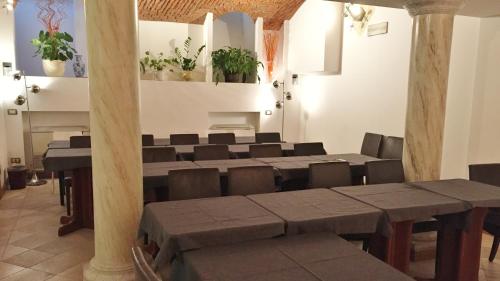 a room with a table and chairs and a piano at Hotel Sempione in Milan