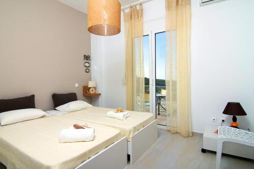 1 dormitorio con 2 camas y balcón en Iperion Apartment G2-2, en Agia Triada