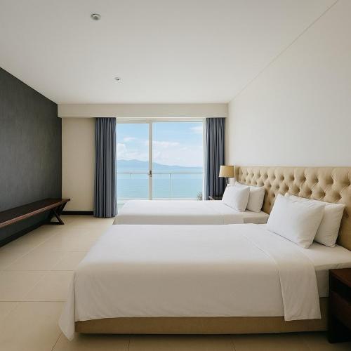 two beds in a hotel room with a large window at Sea View Luxury - Apartments in Nha Trang