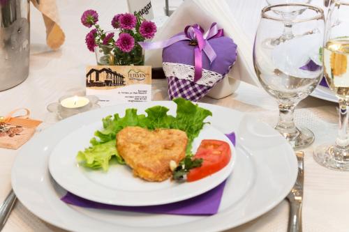 a white plate with food on a table at Family Hotel Teteven in Teteven
