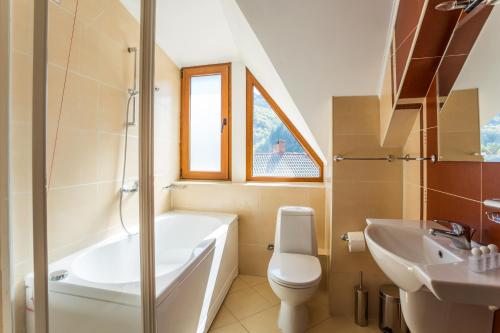 a bathroom with a tub and a toilet and a sink at Family Hotel Teteven in Teteven