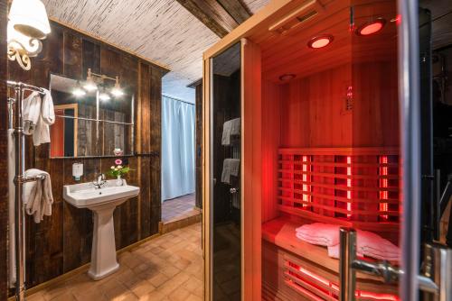a bathroom with a sink and a shower with red walls at Hotel Wellness Goldenes Fass Meißen in Meißen