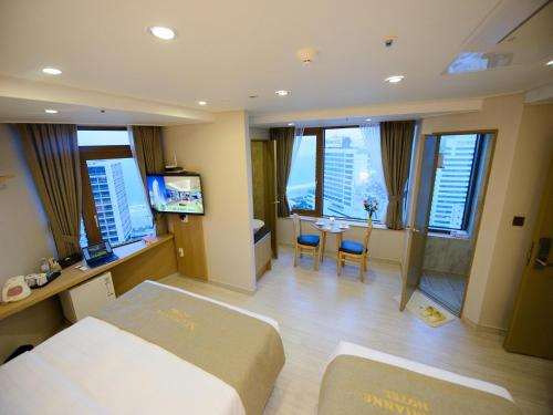 a hotel room with a bed and a table and chairs at Haeundae Marianne Hotel in Busan