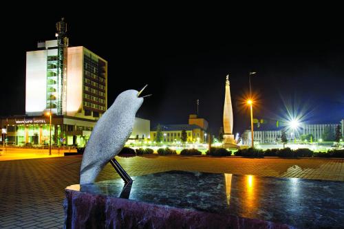 a statue of a bird standing on a fountain in a city at Mercure Marijampole in Marijampolė