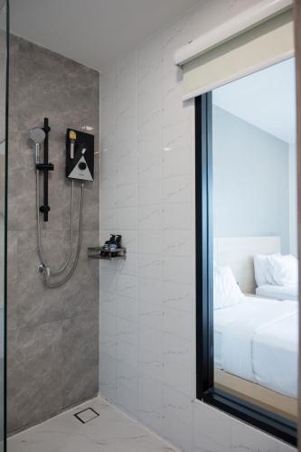 a bathroom with a shower and a bed in a room at Mayuu Ayutthaya Hotel in Ban Ko Rian