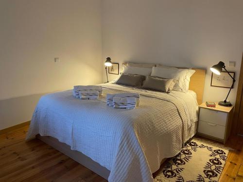 a bedroom with a white bed with two towels on it at Casa do Rio. Sossego à beira rio. in Rio de Onor