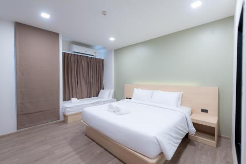 a bedroom with a large white bed and a shower at Mayuu Ayutthaya Hotel in Ban Ko Rian