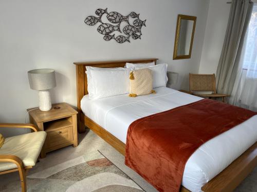 a bedroom with a large bed and a chair at 2 Bed-Sleeps 4-Parking-Pets-10 min walk to Beach in Falmouth
