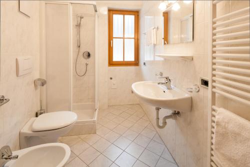 a white bathroom with a sink and a toilet at Vogelmaierhof am Kalterer See in Caldaro
