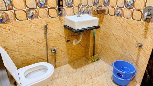 a bathroom with a toilet and a sink at Hotel Parth Inn in Indore